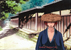 The Hitokiri Battousai walks down the street in his straw hat.